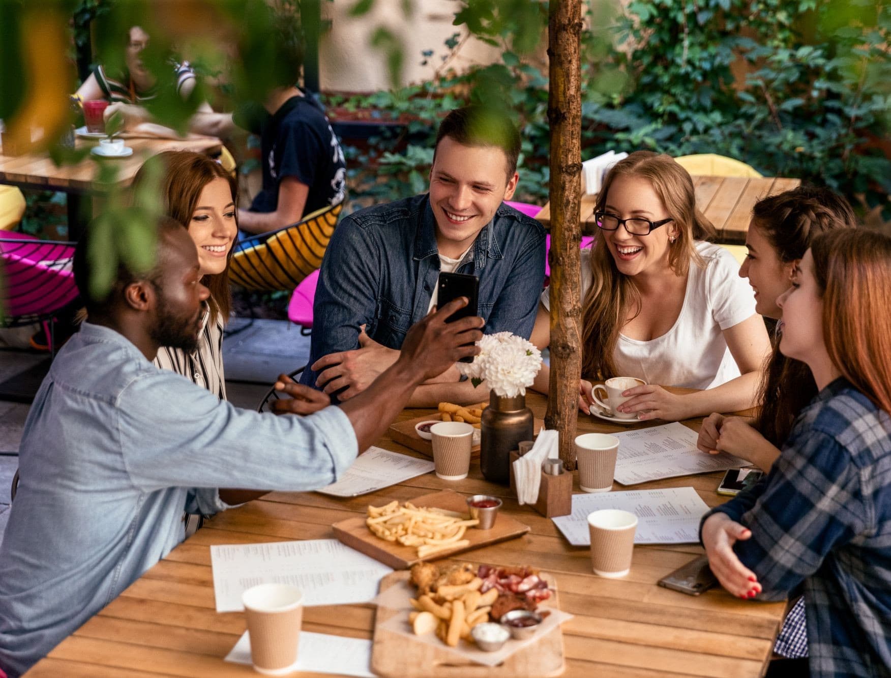 Grupo de amigos comendo, bebendo e tendo uma boa experiência em um bar